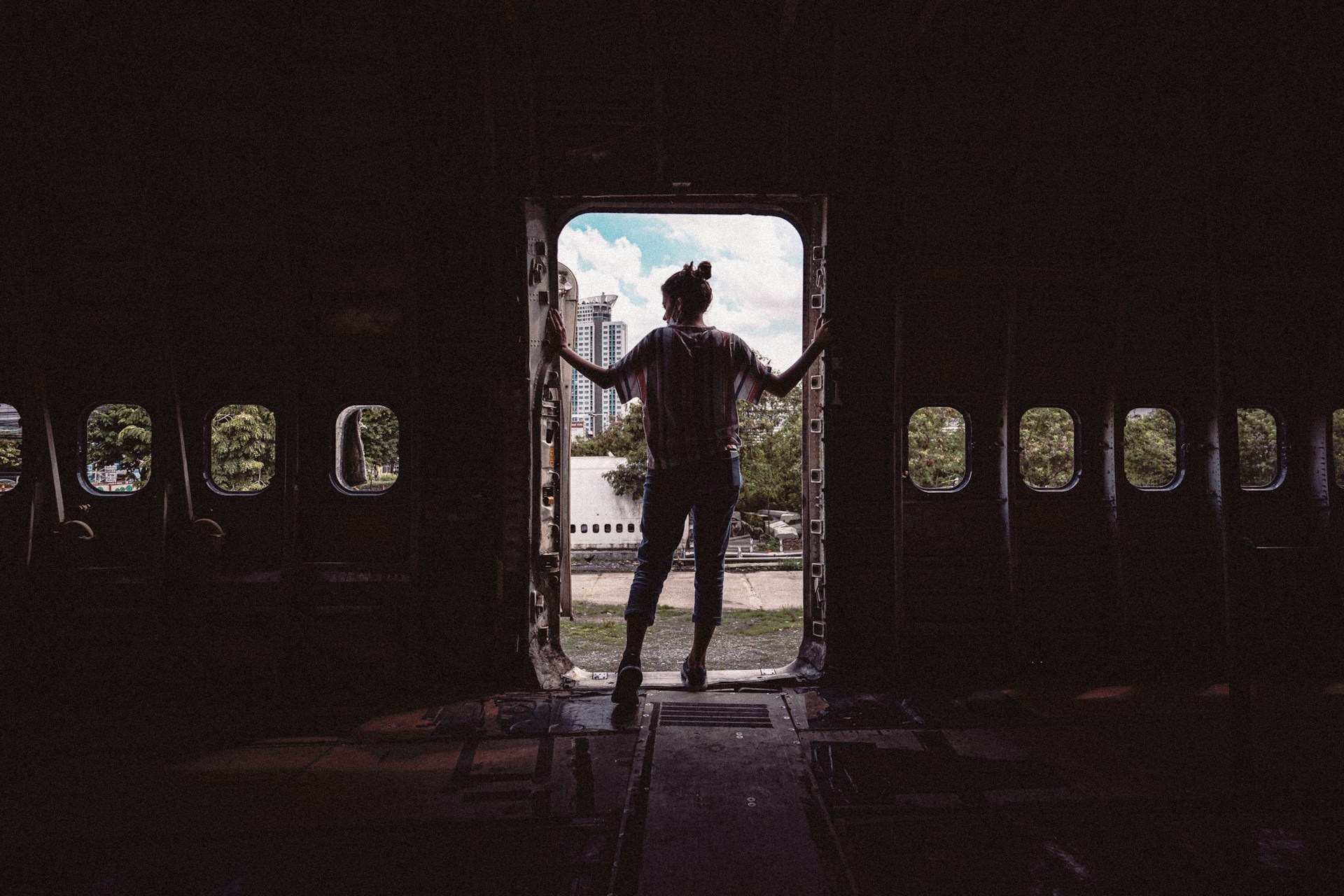 Individual standing in the doorway of an abandoned airplane